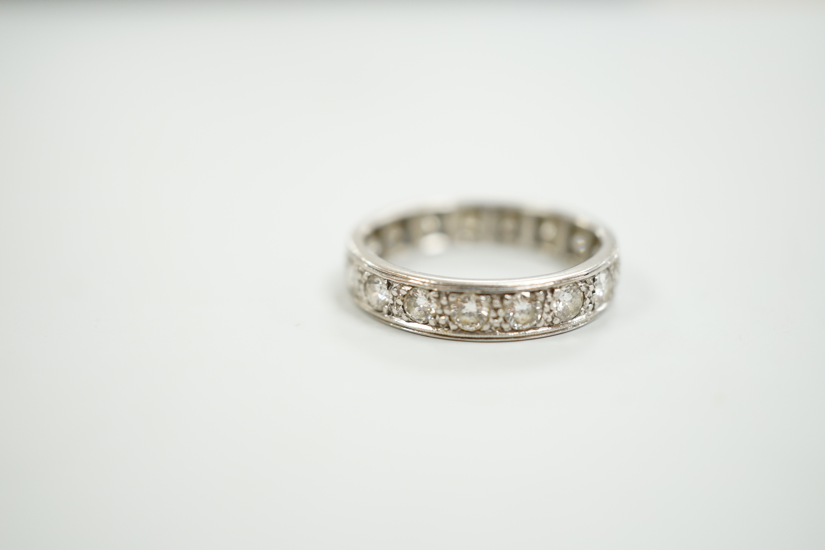 A white metal and diamond set full eternity ring, size M, gross weight 3.9 grams.